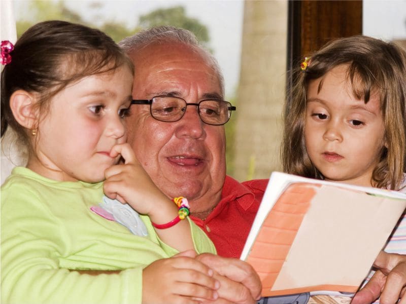 grandfather reading to grandchildren