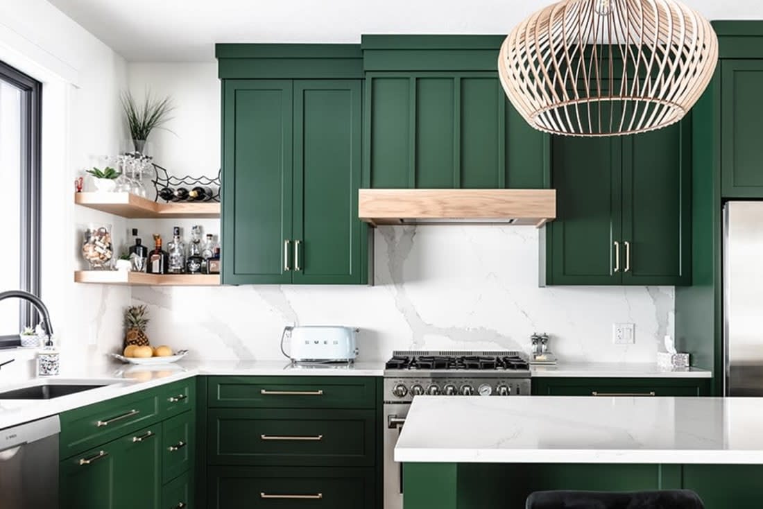 Green kitchen cabinetry with light wood corner open shelves