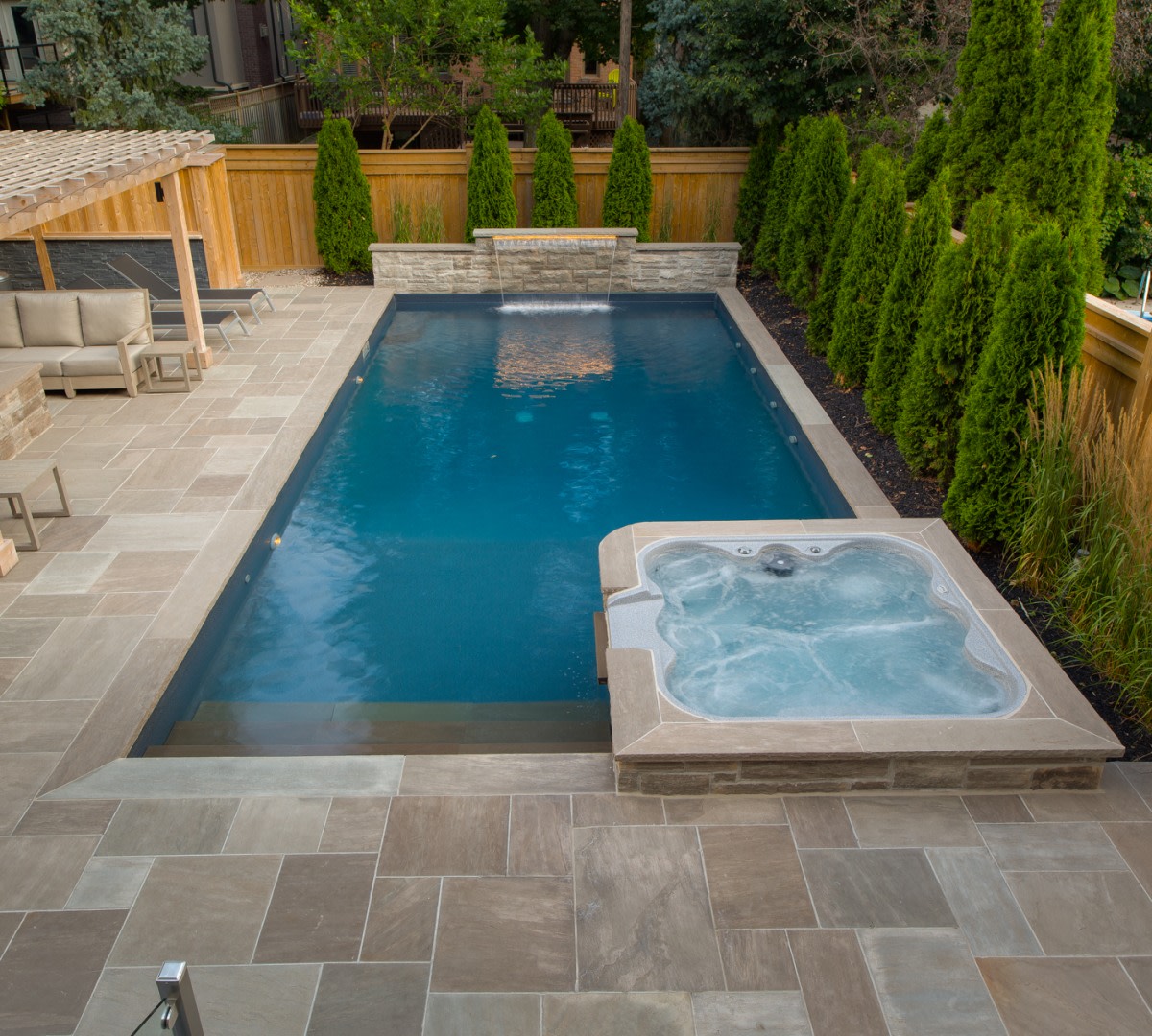 Stone hot tub and pool with waterfall.