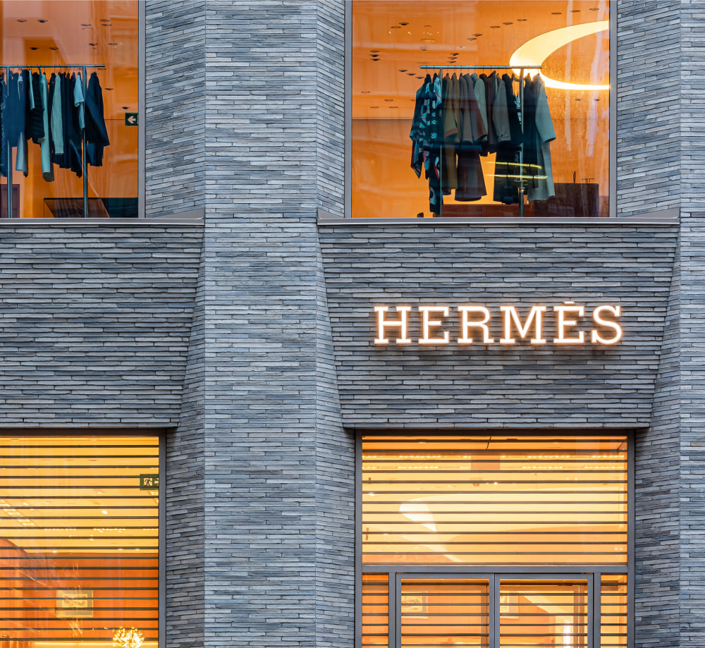 Close up of Hermes storefront with sign and lit up windows.