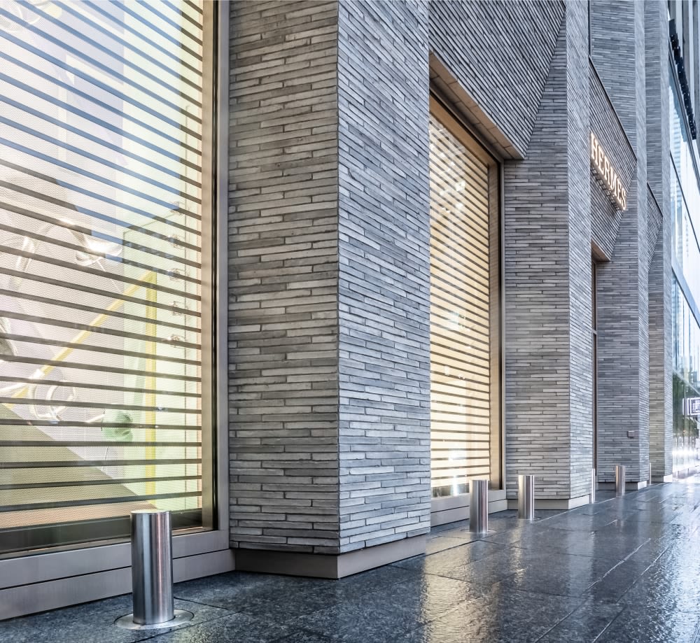 Angled view of Hermes storefront with grey brick.