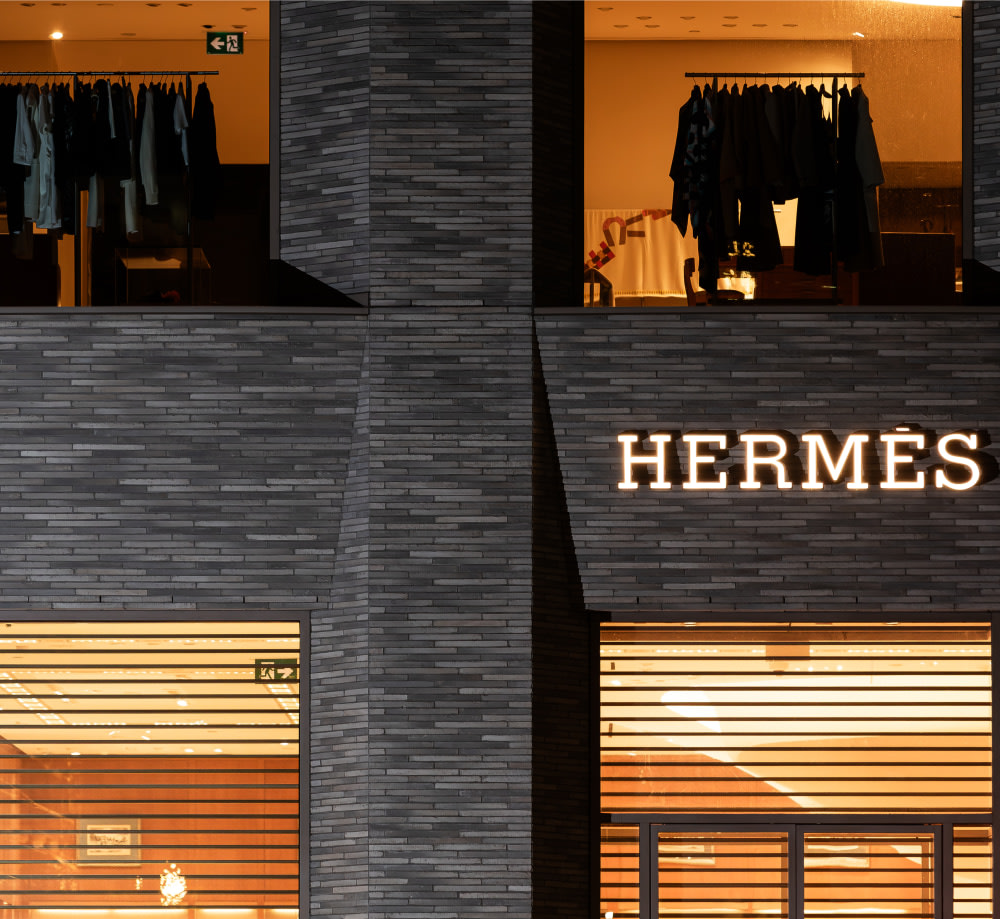 Close up of Hermes storefront with sign at night.