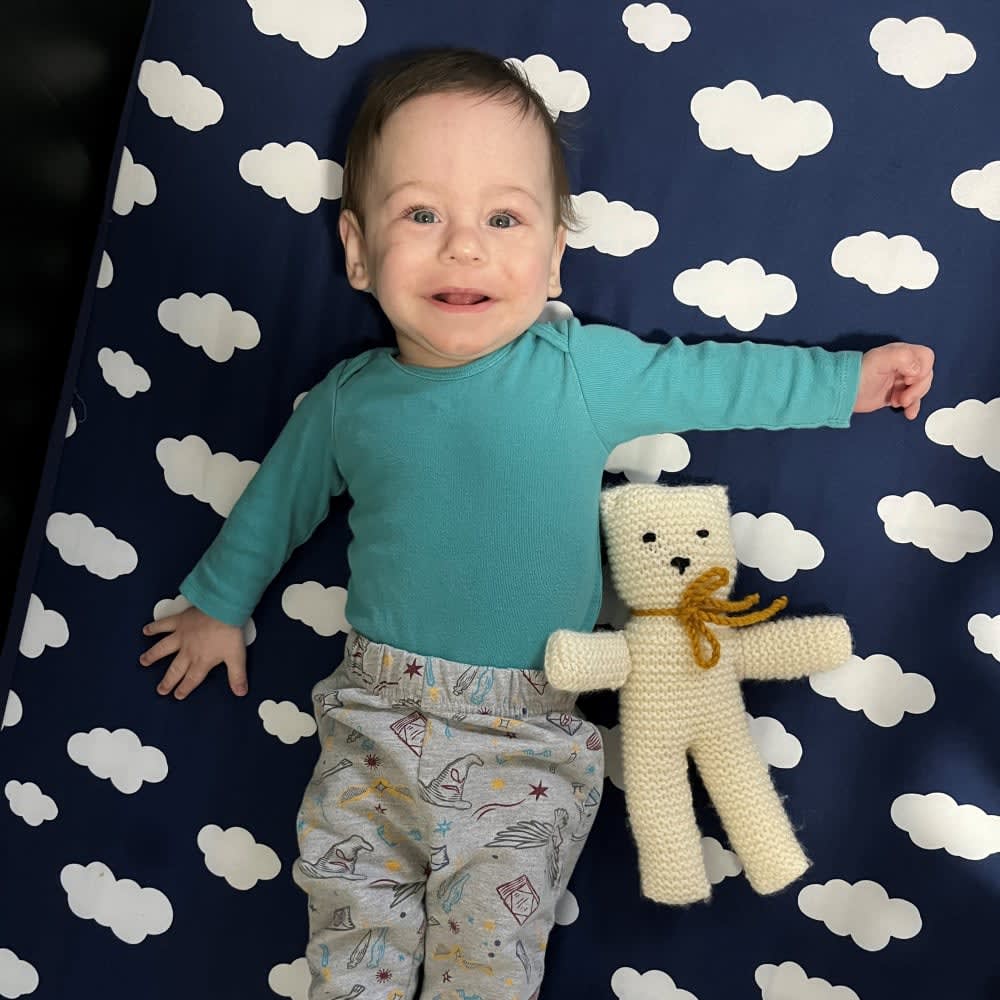 baby boy lying down with stuffed animal