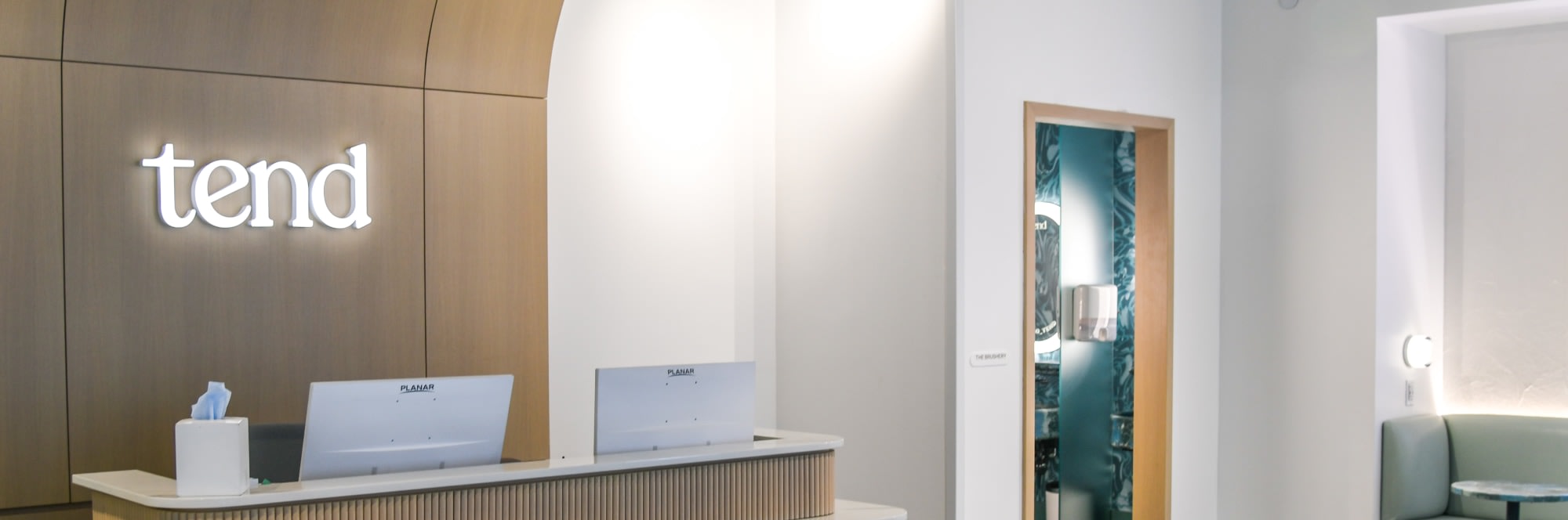 Reception desk in dental studio with open door to brushing area.