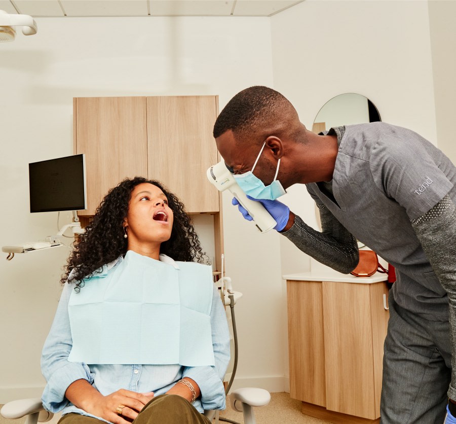 Dental professional using VELscope to exam patient's mouth.