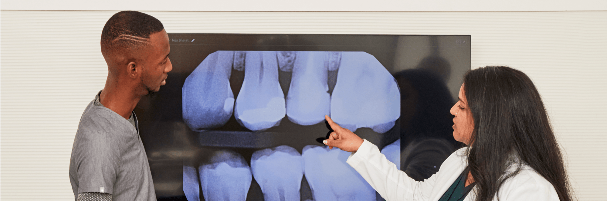 Two team members examine a dental X-ray.