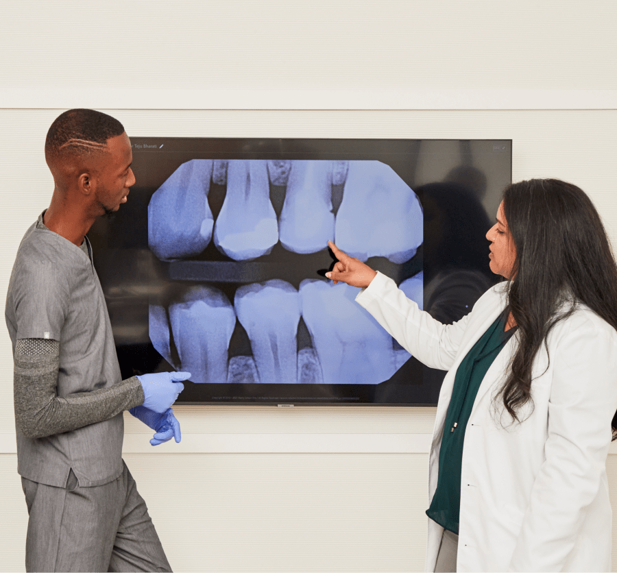 Two team members examine a dental X-ray.