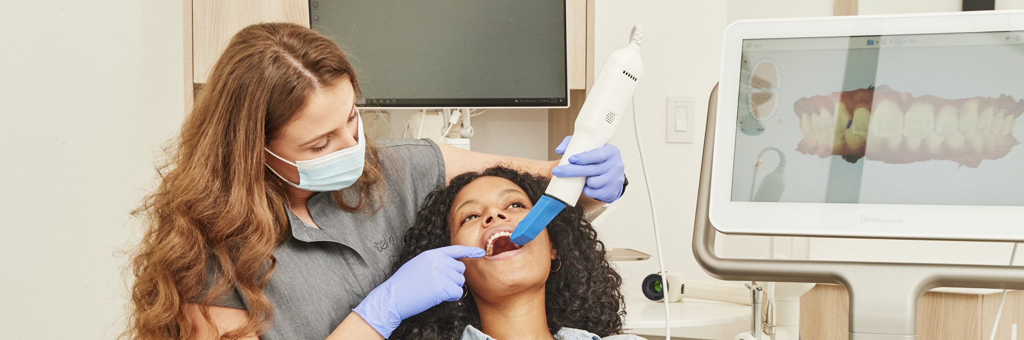 A team member uses an intraoral scanner on a patient.