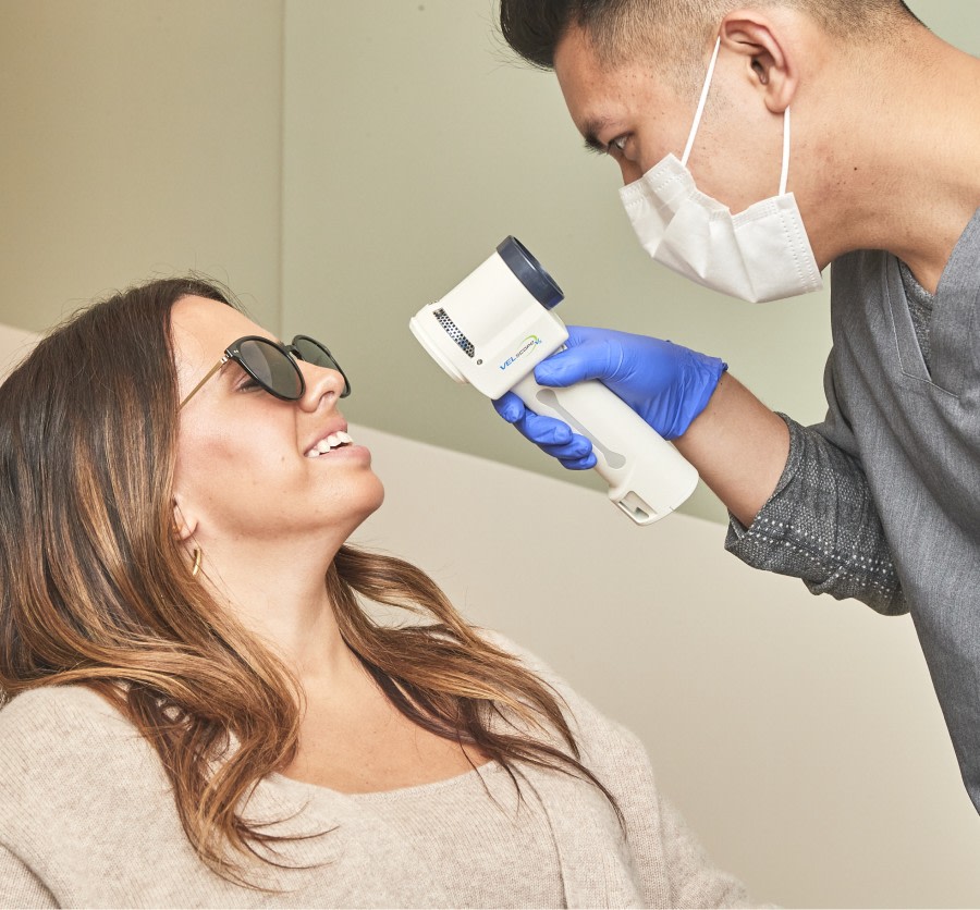 Dental professional using VELscope on patient.