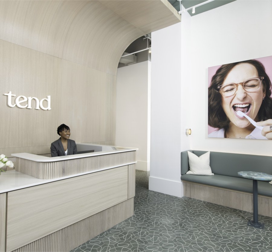 Reception desk and seating area with wall art and small table.