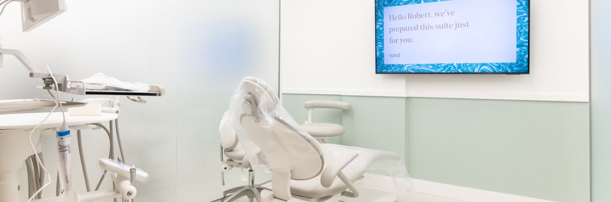 Chair in treatment room with TV displaying welcome information.