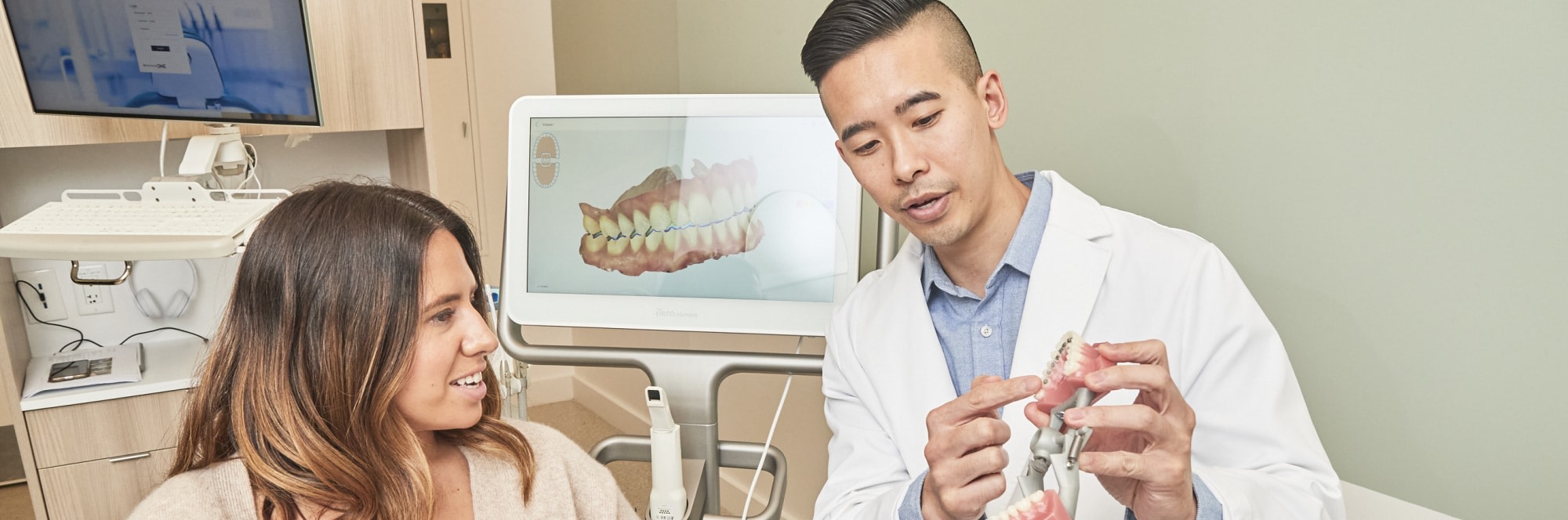 Dental professional showing patient a dental model.