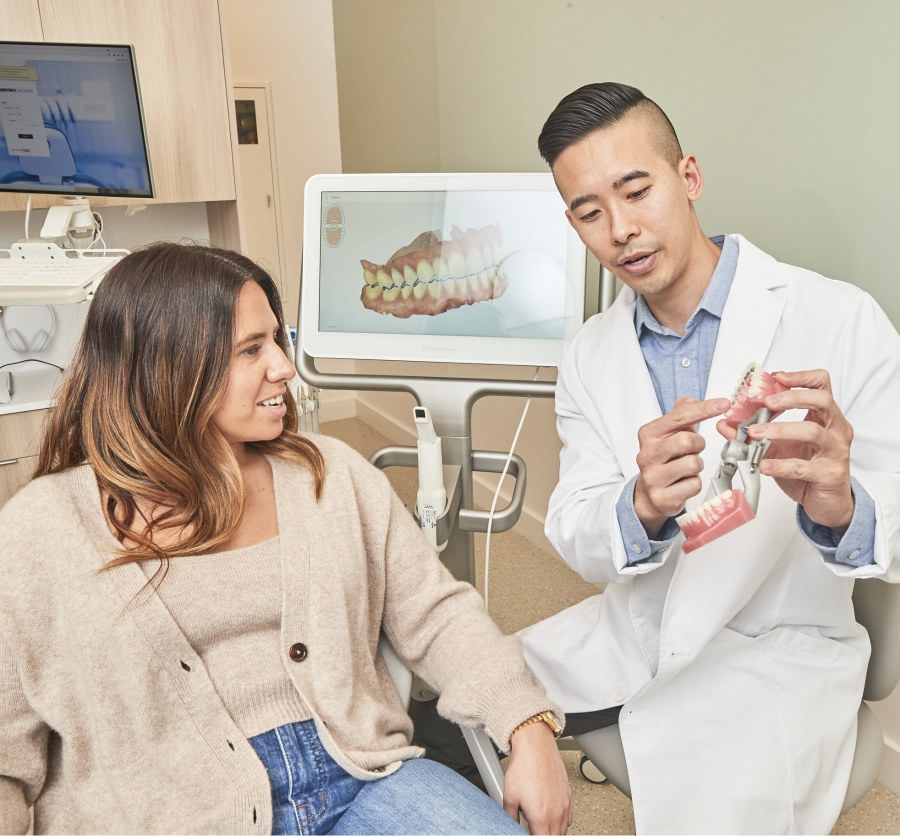 Dental professional showing patient a dental model.