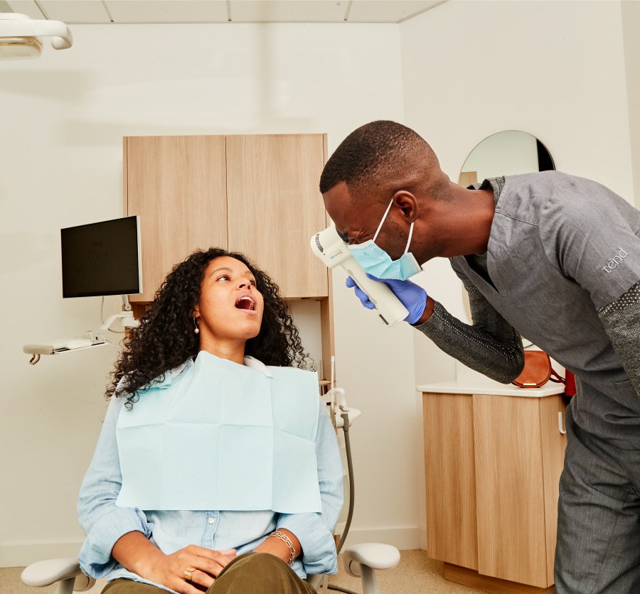 A team member looks at a patient with a VELscope.