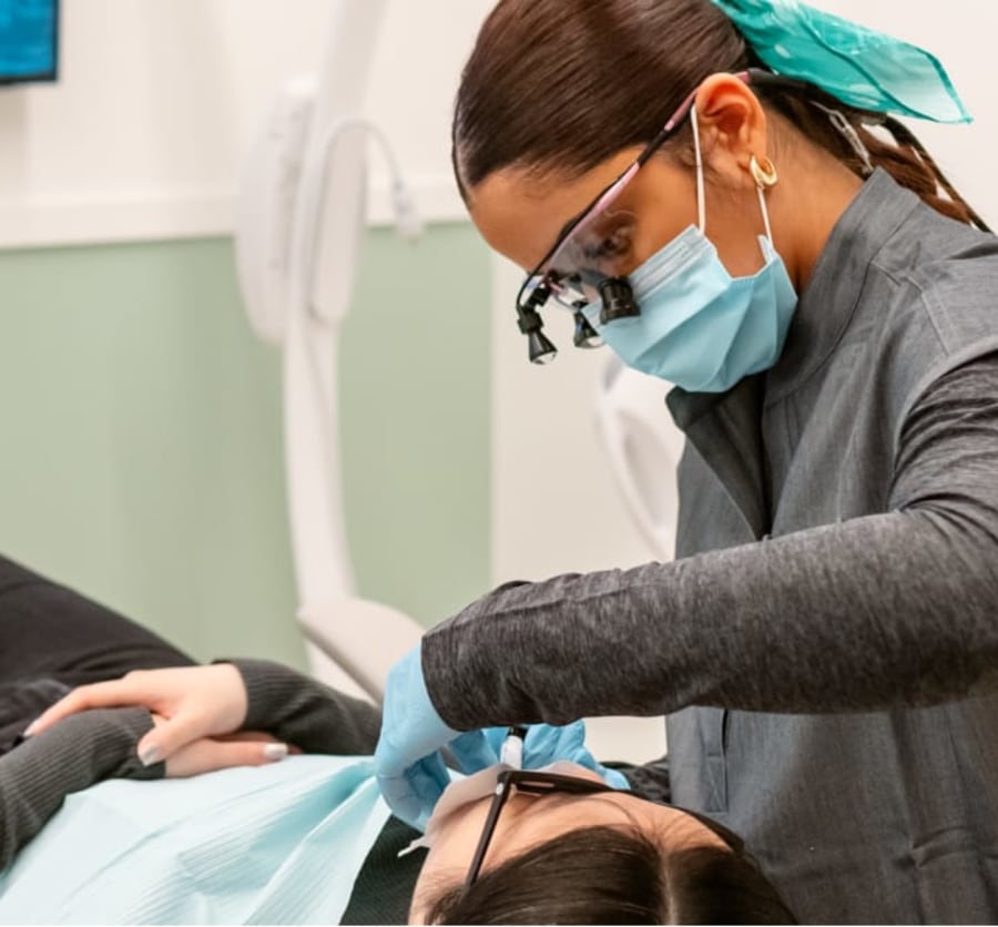 A team member works on a patient's teeth.