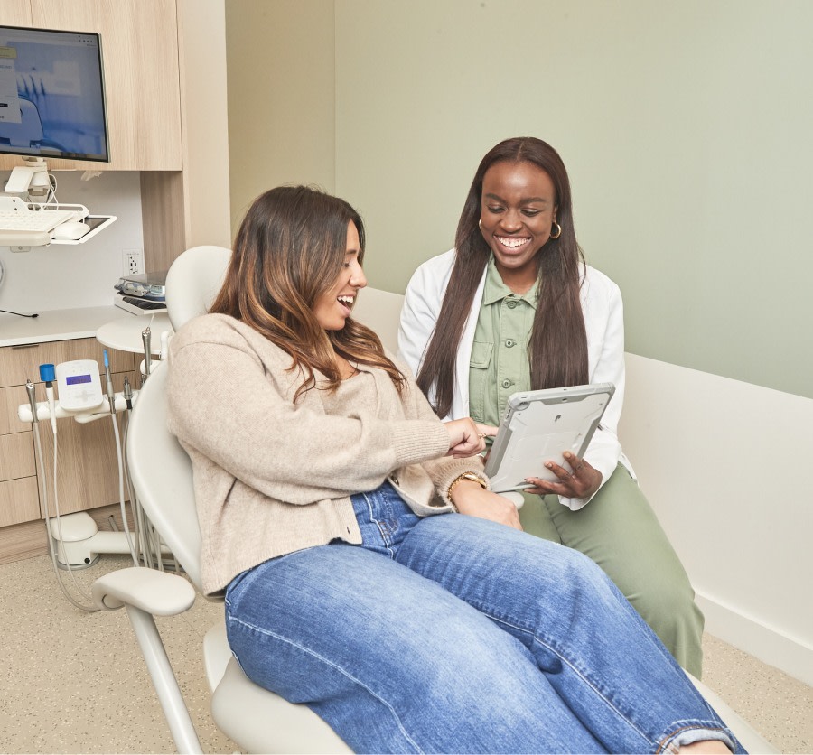 A team member shows a patient something on a tablet.