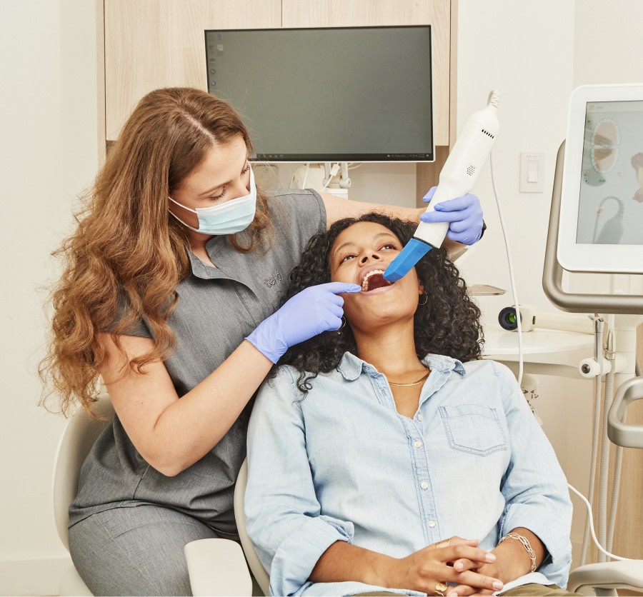 A team member uses an intraoral scanner on a patient.