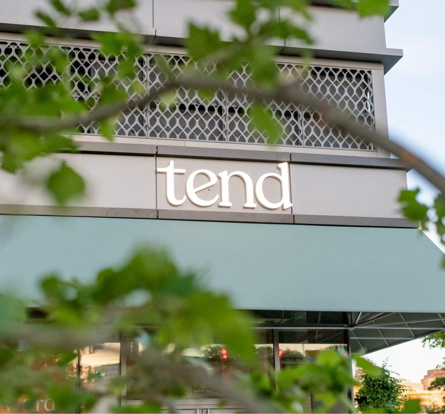 Exterior image of dental studio sign through some tree branches.