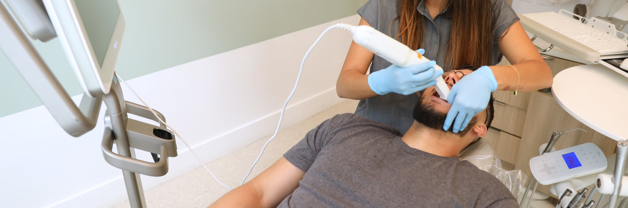 Dental professional performing an intraoral scan on a patient.