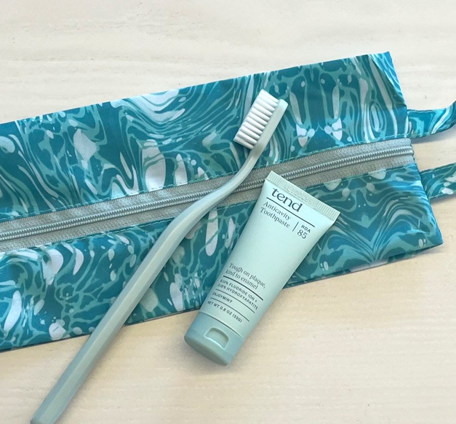 Zippered brush bag containing a toothbrush and toothpaste.