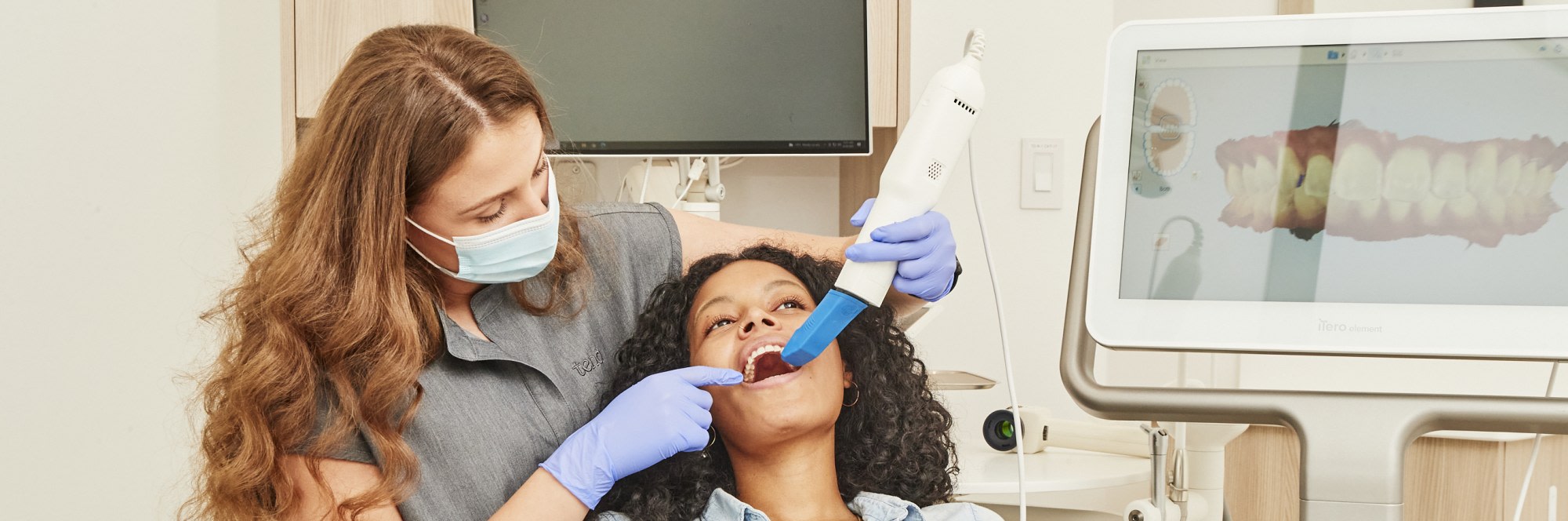 A team member uses an intraoral scanner on a patient.