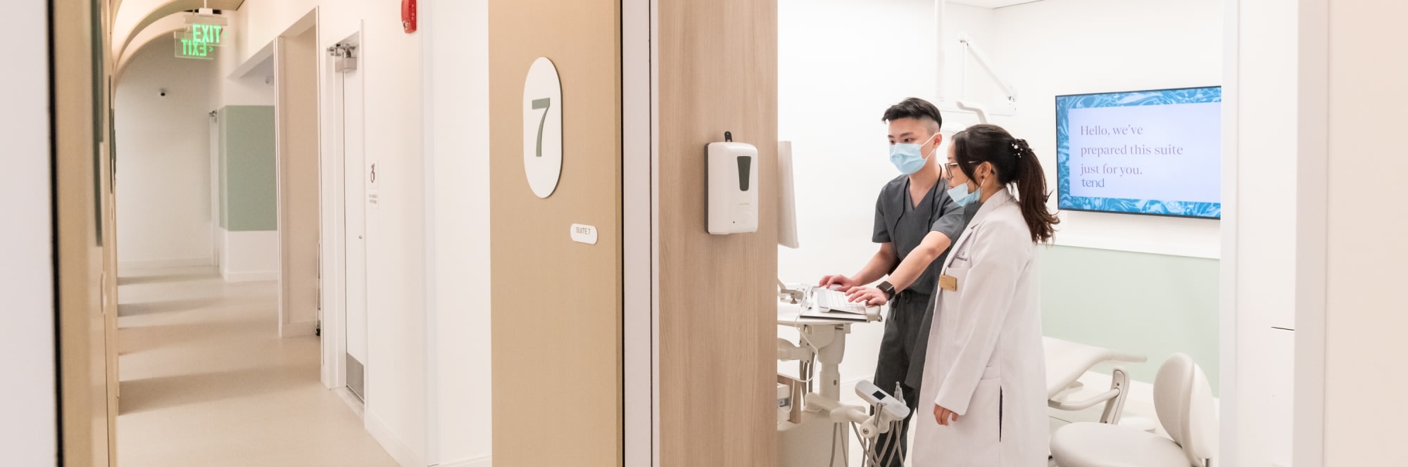 Two team members work in an exam room.