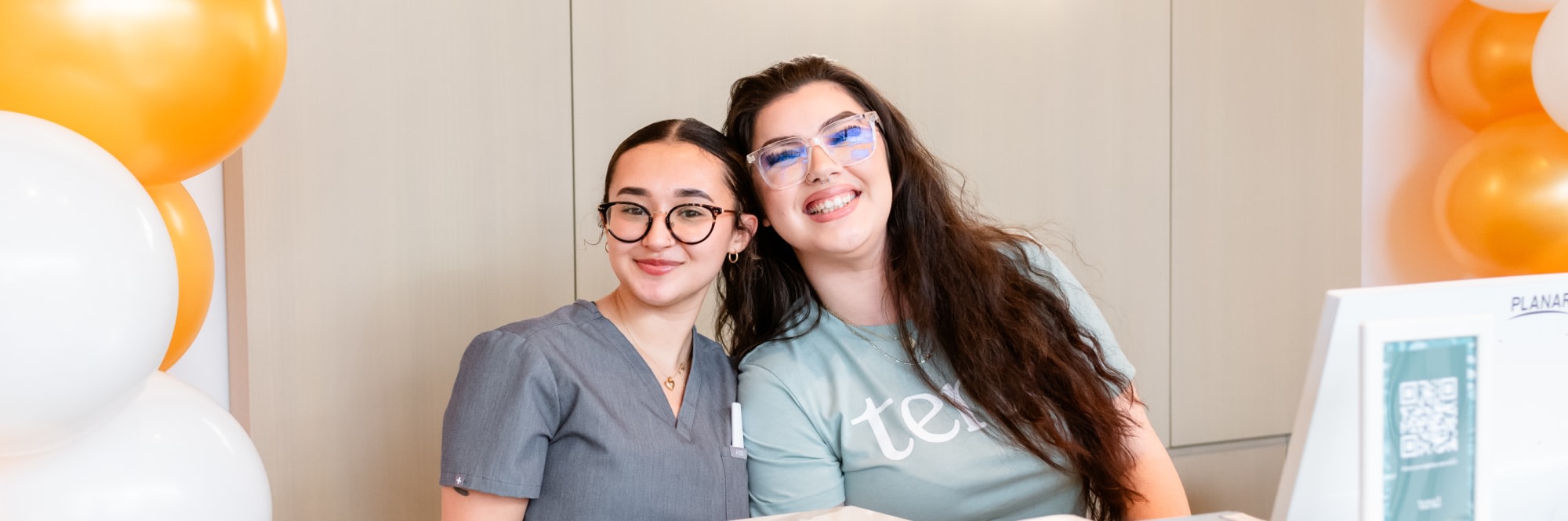 Two team members smile at the camera.