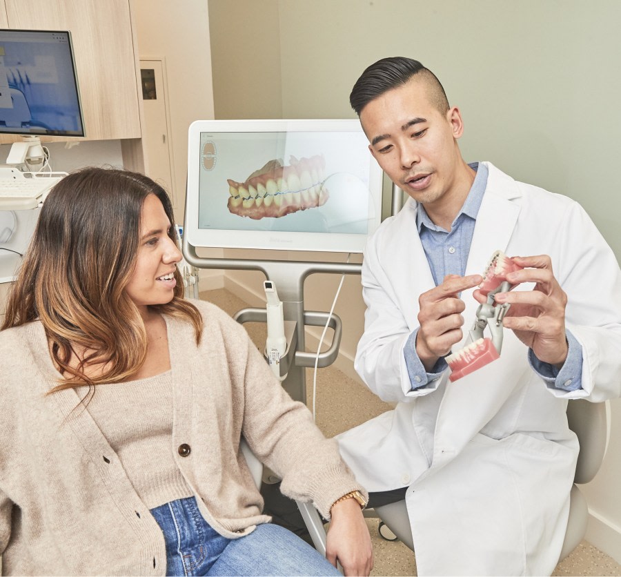 Dental professional showing patient a dental model.