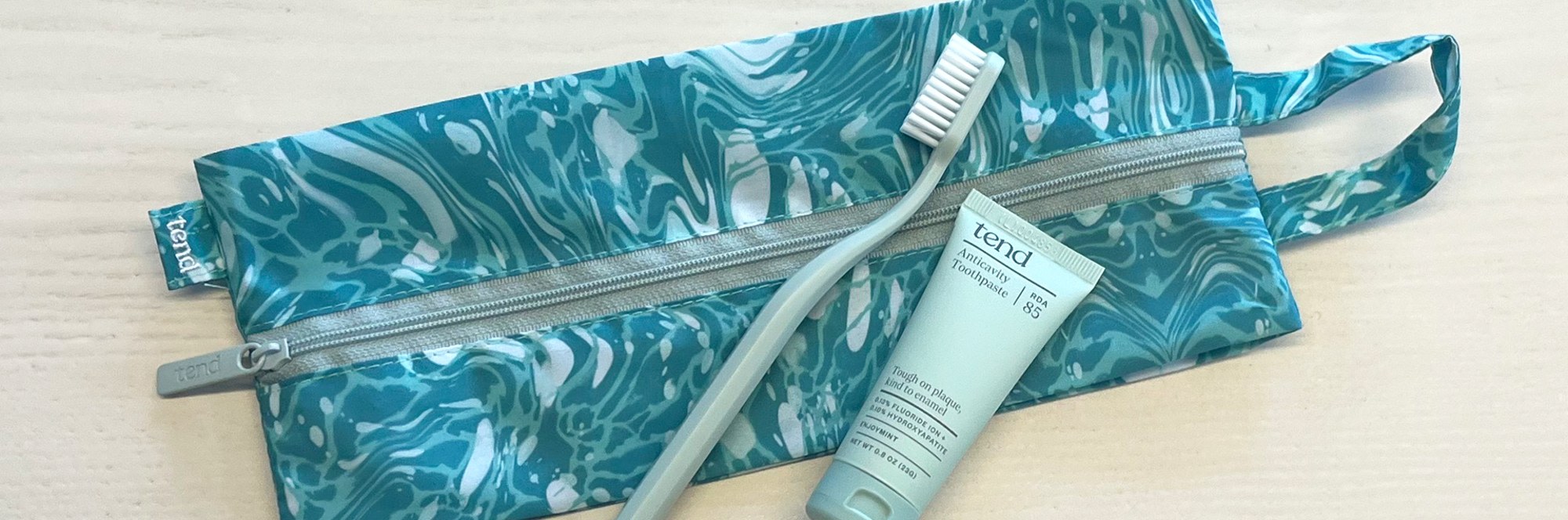 Zippered brush bag with toothbrush and toothpaste.