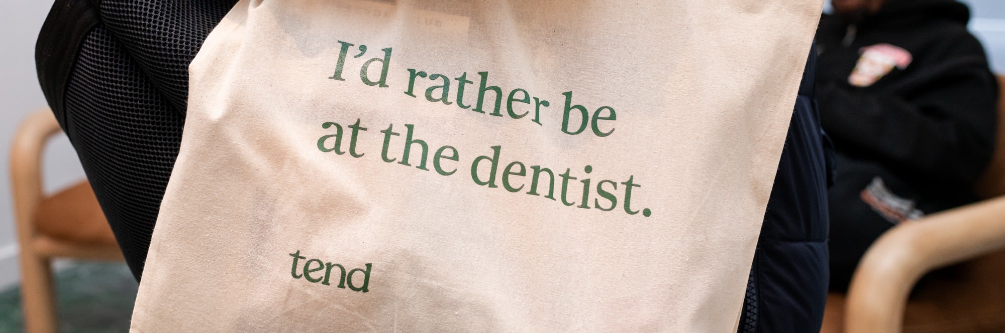 Patient holding bag that says 'I'd rather be at the dentist'.