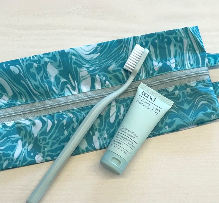 Zippered brush bag with toothbrush and toothpaste.