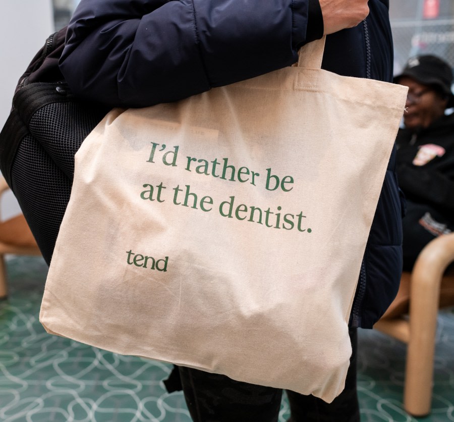 Patient holding bag that says 'I'd rather be at the dentist'.