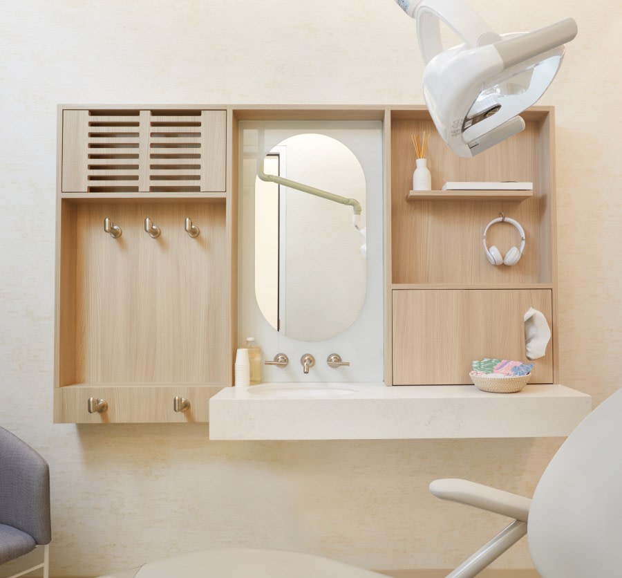 Dental treatment chair with sink, counter, and mirror behind.