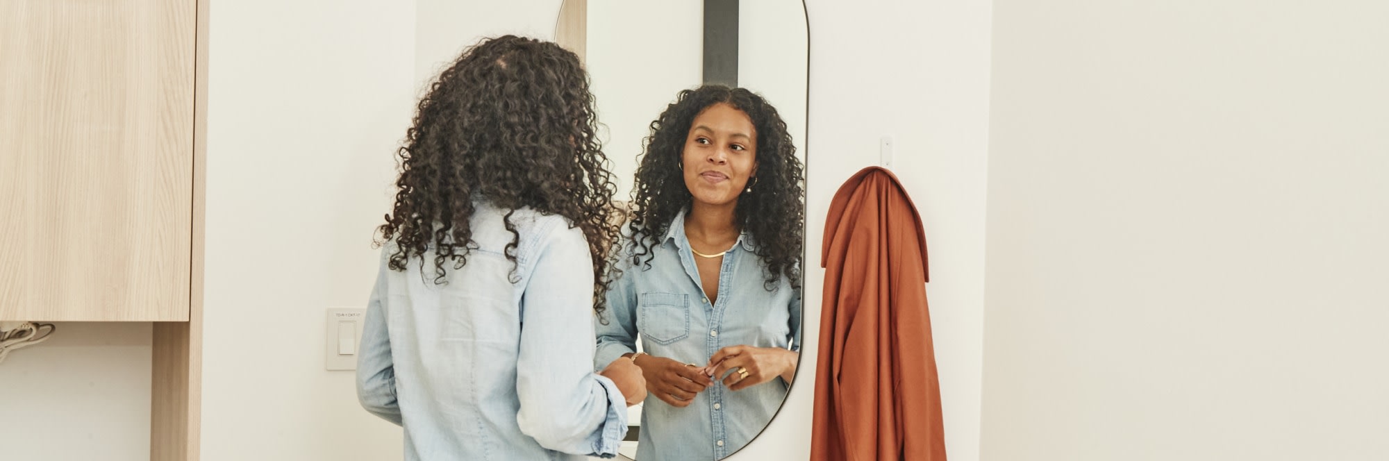 A patient smiles at herself in the mirror.