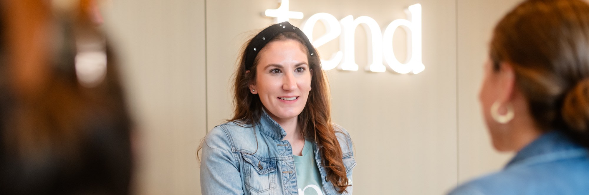 A team member smiles from behind the reception desk.