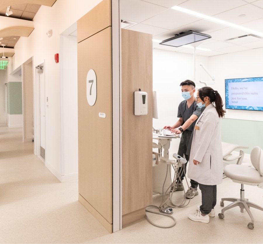 Two team members work in an exam room.