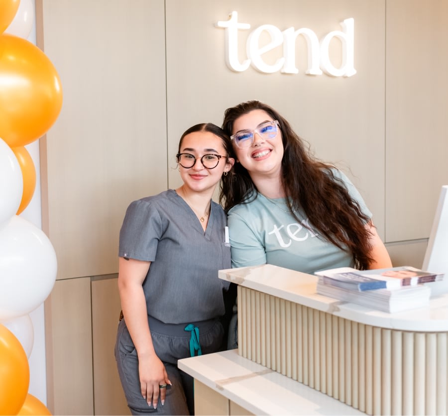 Two team members smile at the camera.