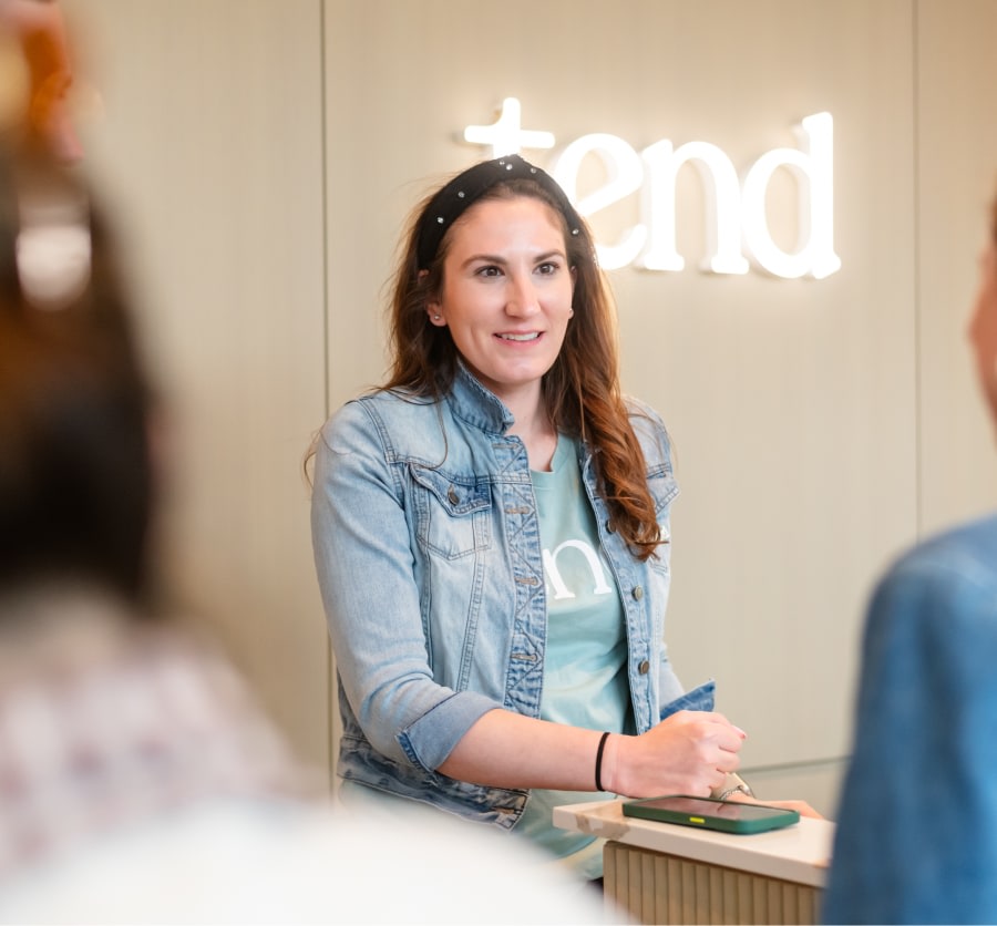 A team member smiles from behind the reception desk.