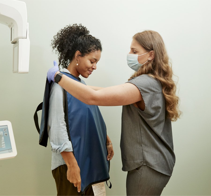 A team member preps a patient for an X-ray.
