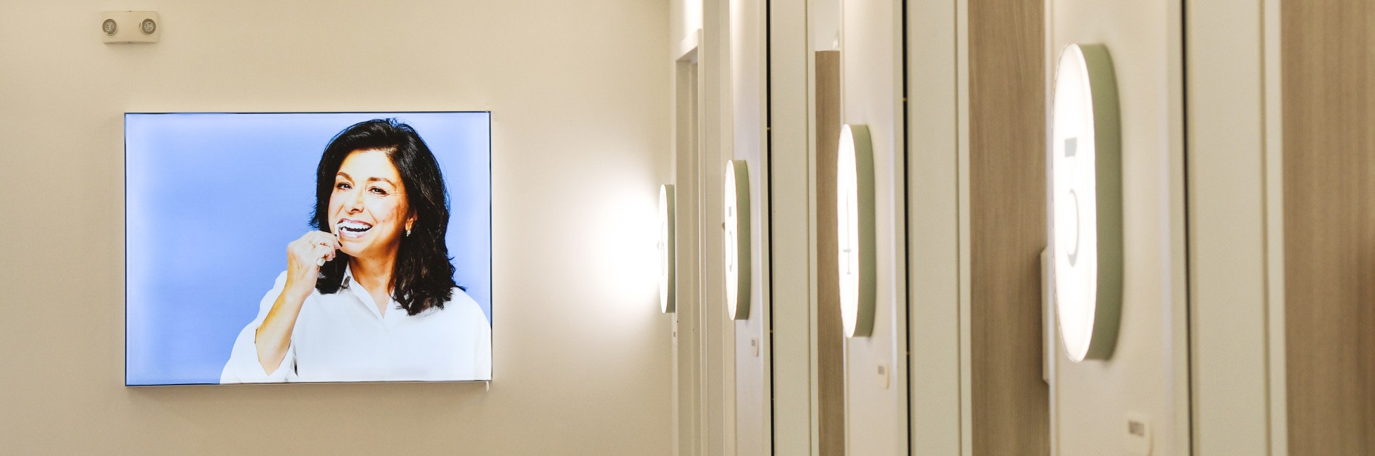 Hallway in dental studio with wall art of woman brushing teeth.