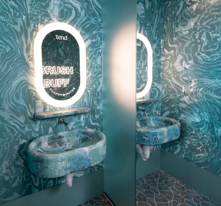 Sink with mirror in teeth brushing area at dental studio.