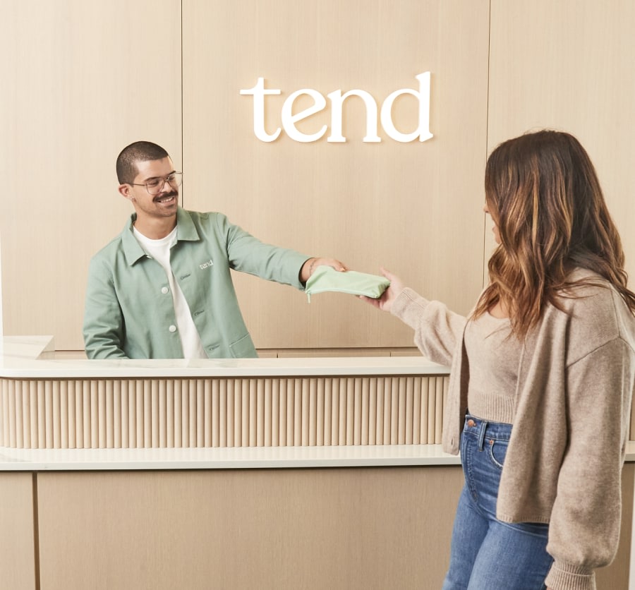 A team member greet a patient at the reception desk.