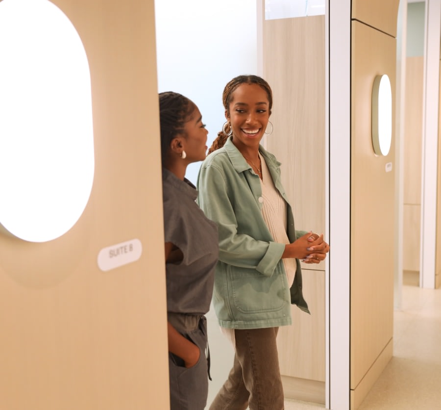 Dental professional and patient walking out of treatment room.