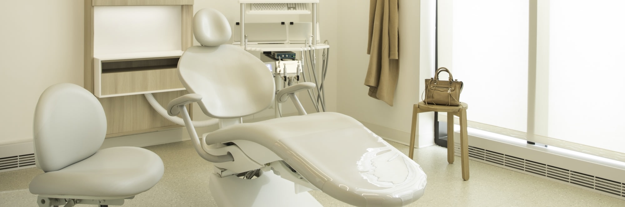 Chair and TV with dental equipment in treatment room.