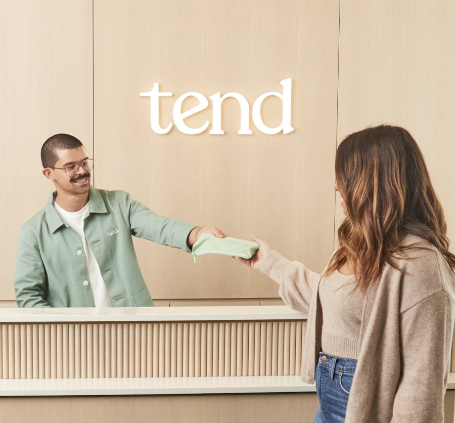 Dental receptionist handing brush bag to patient.