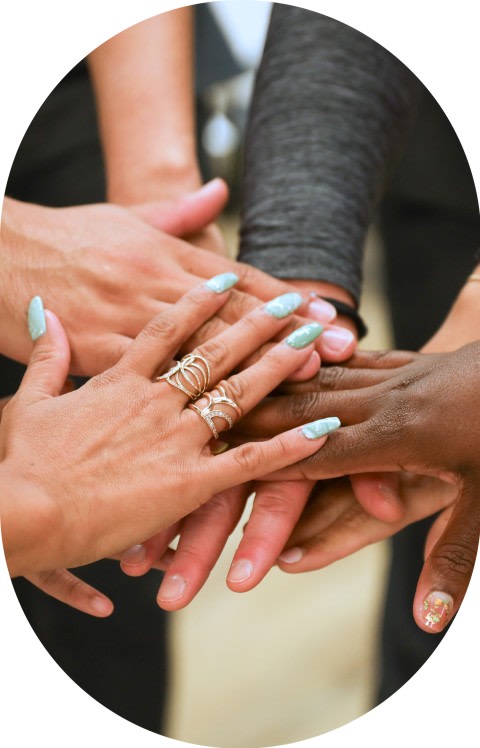 Team members are doing a hands-in cheer.