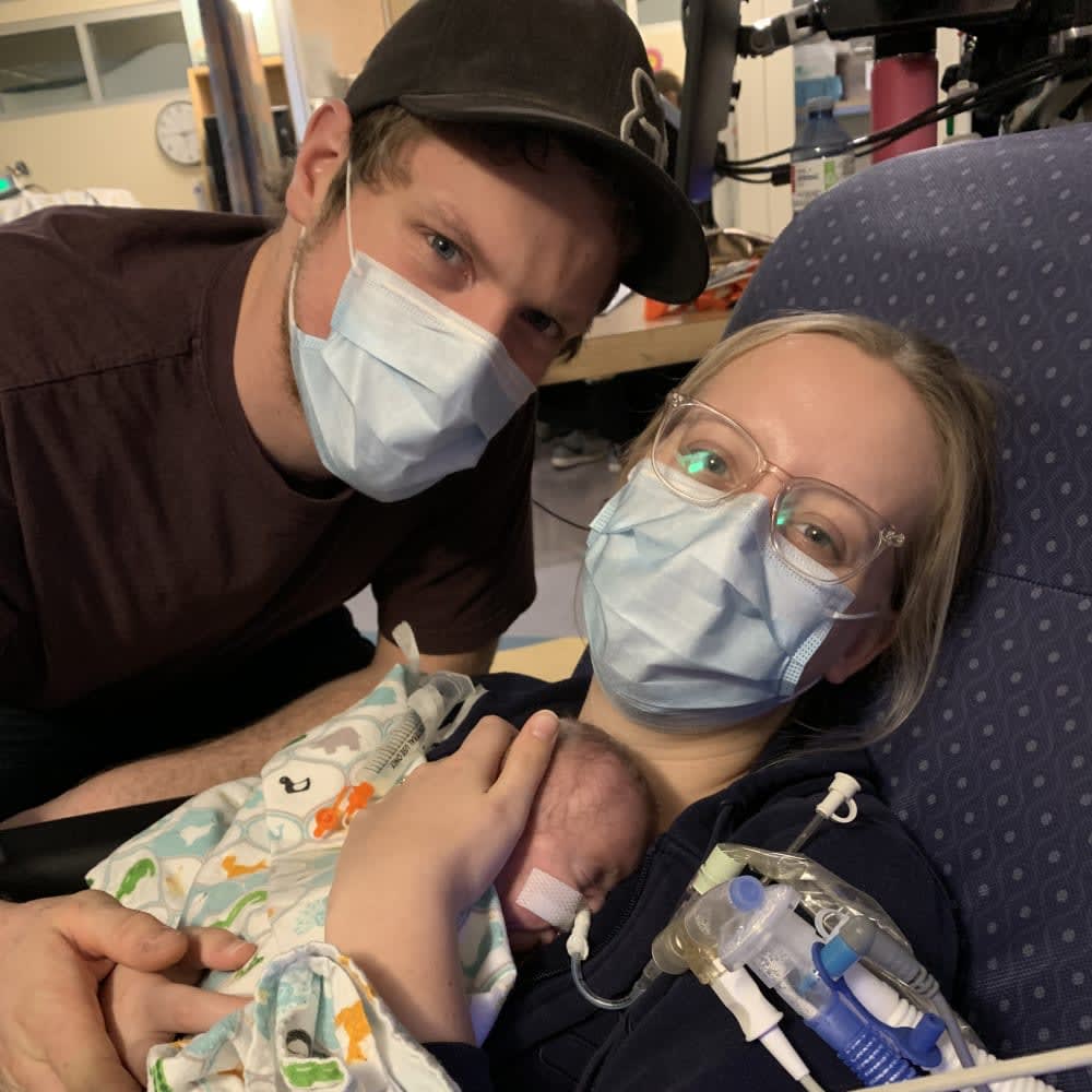 mom, dad, and new born baby in hospital