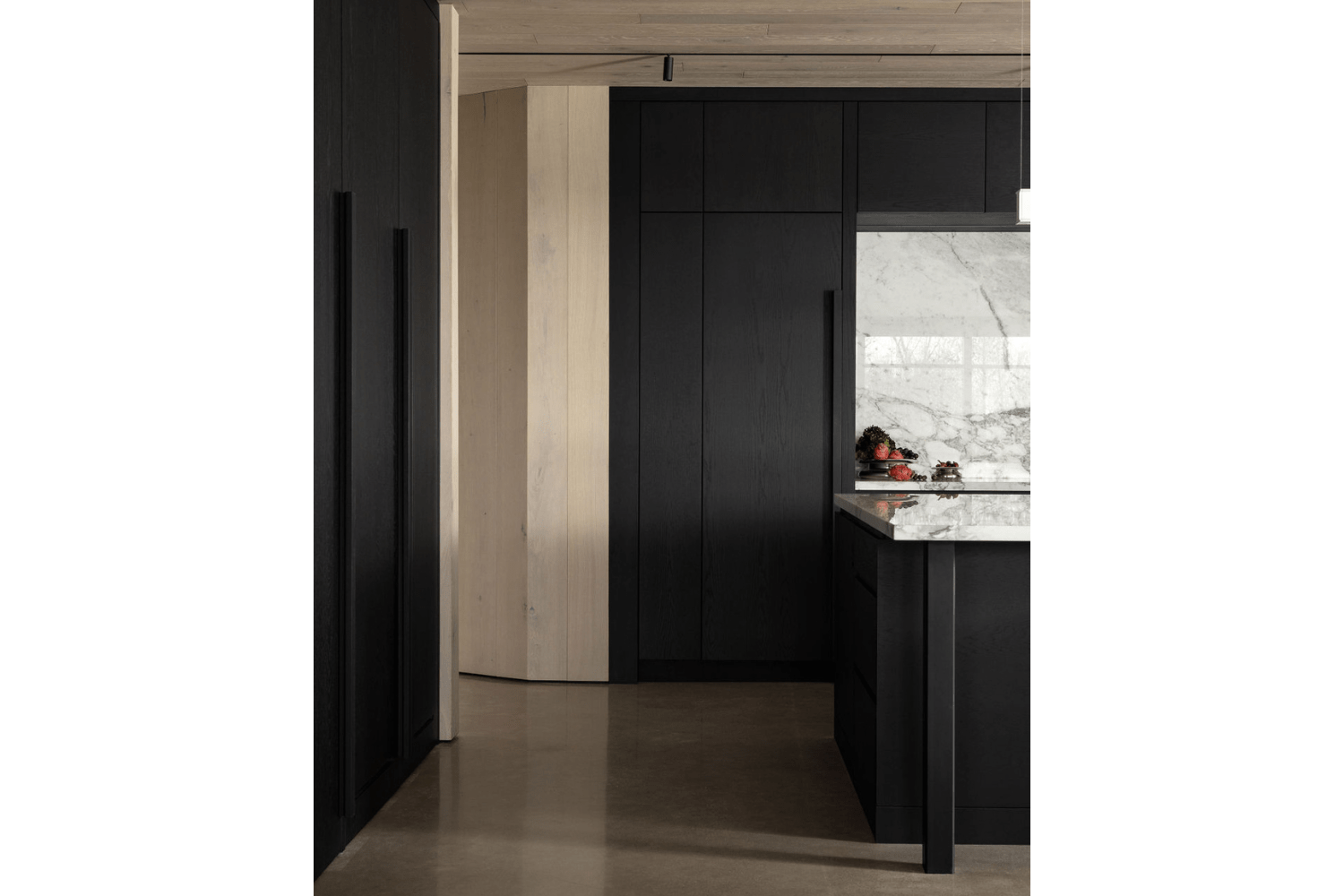 Black kitchen cabinets paired with organic wood walls