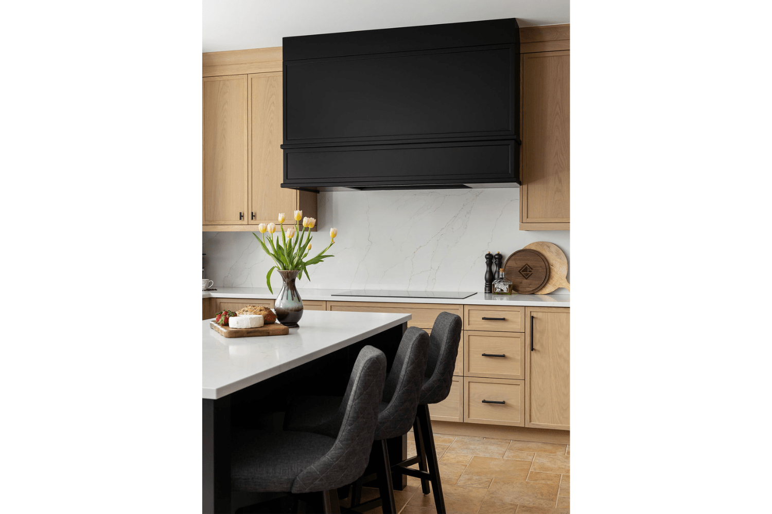 Custom large black range hood over countertop stove