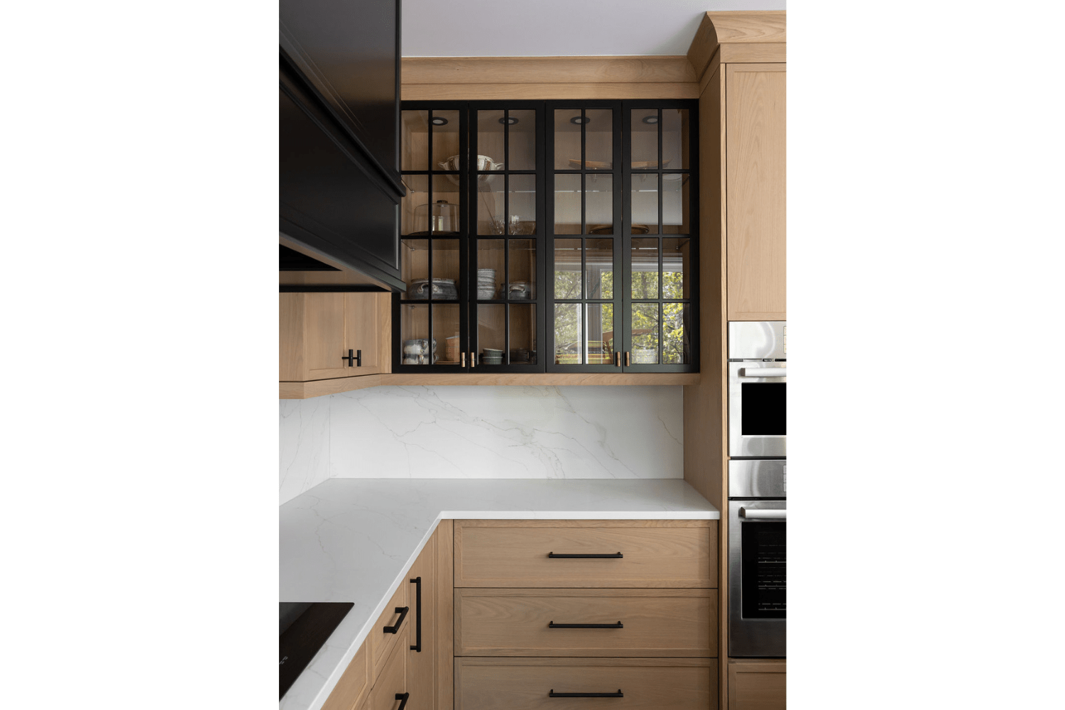 Black-framed glass upper cabinet doors with brass knobs
